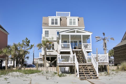 Coastal beach house with elevated design and wraparound porches overlooking the oceanfront.