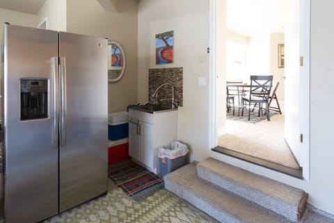 Sink, large fridge, filtered water, and ice machine off living room