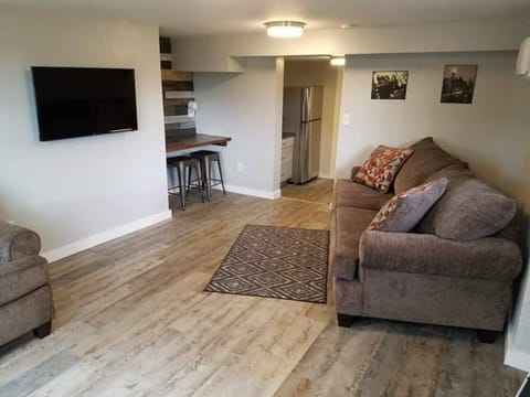 Living room with comfy couches and flat screen tv with cute nook to work or eat at. 