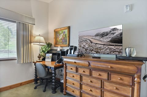 Guest bedroom with desk for working guests, Keurig coffee maker and flat screen TV