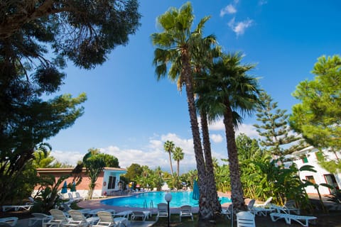 Outdoor pool, open 9:00 AM to 8 PM, pool umbrellas