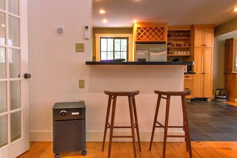 - Breakfast bar with two stools and wine rack cabinetry nearby   - Open-concept design connects kitchen and living space beautifully   - Perfect cozy nook for coffee mornings or evening wine chats