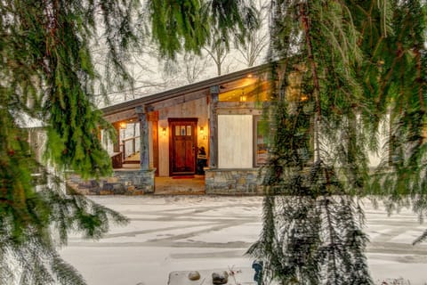 - Charming cabin exterior framed by snowy evergreens   - Warm glowing lights and timber design welcome you home   - Ideal mountain retreat for winter getaways and cozy evenings
