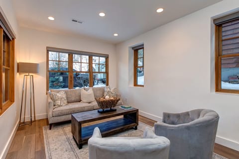 Unwind in our stylish living area. Features large wood-framed windows, comfortable seating, and a warm atmosphere. Perfect for relaxing after a day exploring Park City.