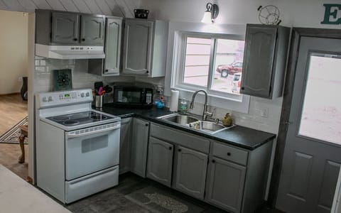 Full kitchen with door out to area to grill and/or sit at picnic table.