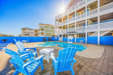 Relax in bright blue Adirondack chairs beside your private pool, watching the sun set over this coastal retreat.