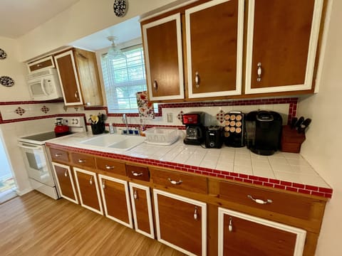 Coffee maker, blender, toaster, stove, microwave, cups, plates, silverware.