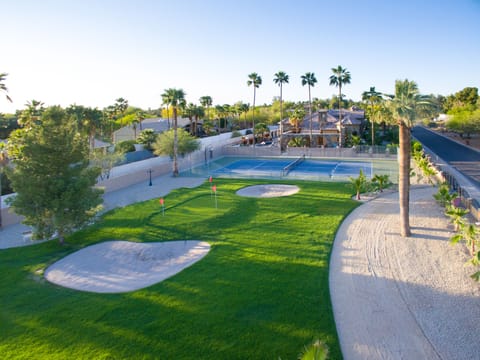 Resort-style retreat with private tennis court, putting green & palm trees.