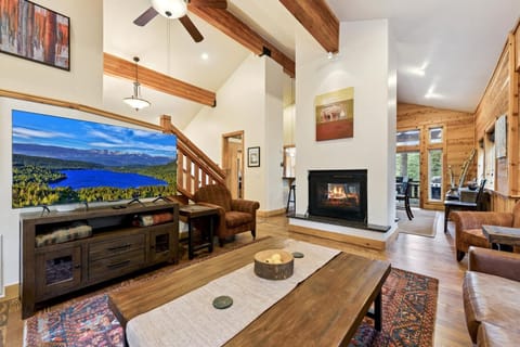 The living room on the main level features a large leather couch, smart TV, and gas fireplace. 