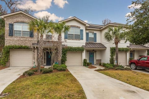 Two-story brick property exterior with palm trees and garage