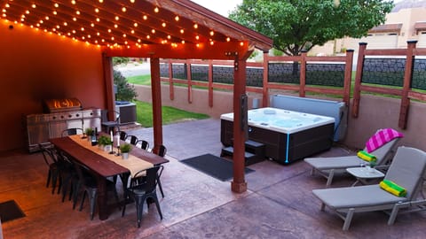Patio oasis that includes private hot tub & 10 person outdoor table. 