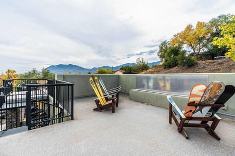 Fire pit rooftop with Adirondack-style chairs and wide views beyond the railing. Start slow mornings outside or wind down in the fresh air, soaking in the open sky and distant landscape from this relaxed outdoor perch.