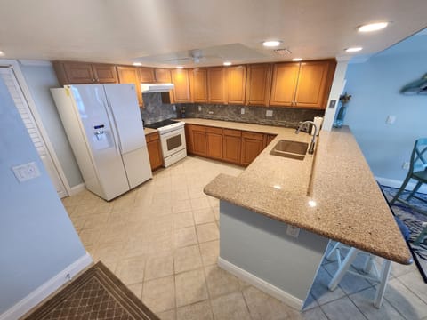 Fully stocked oversized kitchen with granite counters and new appliances.