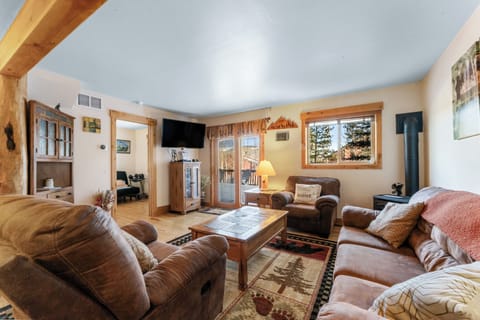 Sink into plush leather seating by your crackling fireplace, where exposed beams and mountain views create the perfect cozy retreat.