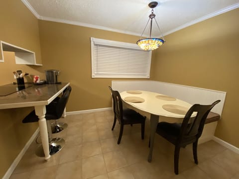 Dining table with seating for 5-6 guests and additional 2 barstools