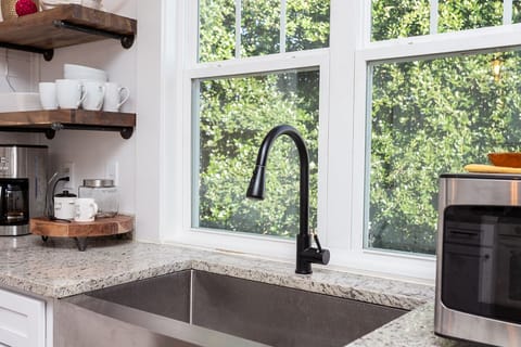 Large farm sink, plenty of dishes, pots, pans, utensils, and small appliances