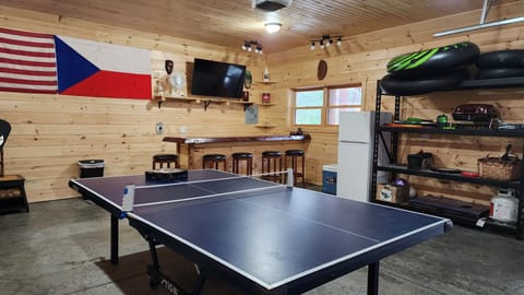Bar in garage with ping pong table and smart tv