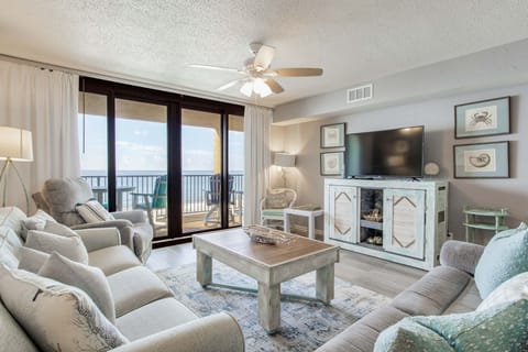 Open-concept living room with Gulf views and vinyl plank flooring at Wind Drift