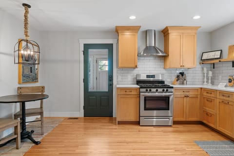 Your fully equipped kitchen features warm wood cabinets, stainless appliances, and subway tile backsplash - perfect for creating memorable meals.
