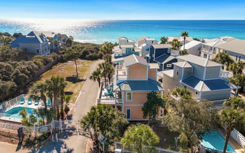 Coastal vacation rental community featuring colorful beach houses, swimming pools, and pristine turquoise waters just steps away.