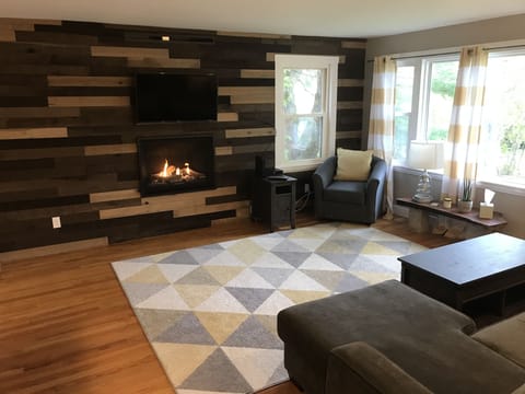 Living room with gas fireplace and flat screen smart TV.   