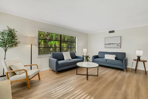 Lounge in the spacious living room that features 2 huge couches, a smart tv, and a lot of natural light.