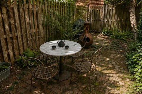 Enjoy a peaceful outdoor space with a charming brick patio, bistro-style seating, and lush greenery. Perfect for morning coffee or an afternoon break.