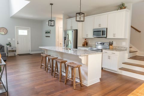 Kitchen. Stairs to bedrooms and another full bathroom. Extra seating at island.