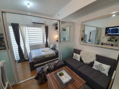 Living room with sofa bed & center table with stool chairs underneath.