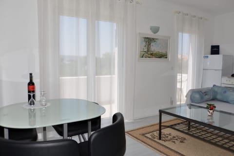 Living room with sofa bed, kitchen and dining area.