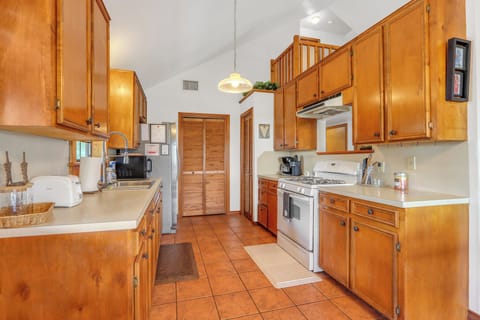 The kitchen is stocked with oven, stove, refrigerator, and microwave