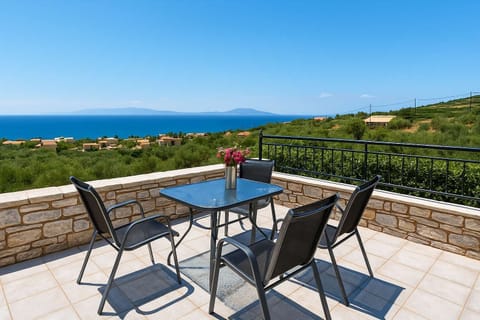 Balcony with Outdoor Dining and Scenic Views – Enjoy relaxing moments on the balcony, complete with a dining table and chairs, perfect for morning coffee or evening drinks while overlooking the sea and surrounding olive groves.