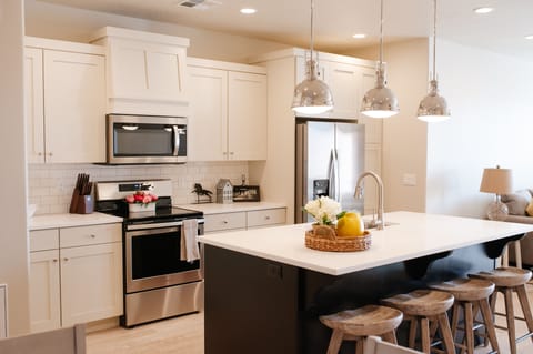 Fully equipped kitchen featuring island seating and stainless appliances.