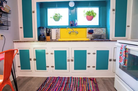 Charming 1930s kitchen with vintage sink, bright colors & Bluebird whimsy.