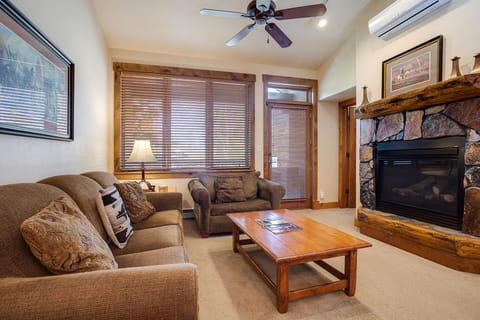 Sink into plush seating by your stone fireplace, where warm wood accents and mountain views create the perfect retreat.