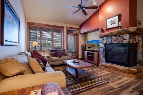 Sink into plush sofas by your stone fireplace, where warm mountain evenings become unforgettable with crackling flames and peaceful views.