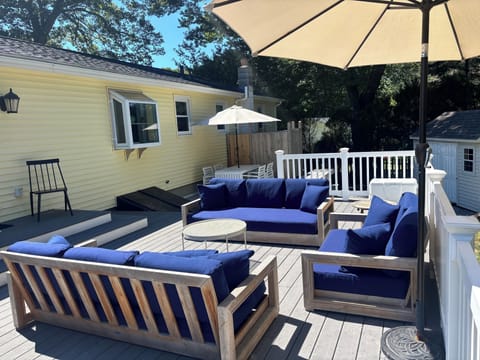 3-tiered deck with couches, table, grill and outdoor shower