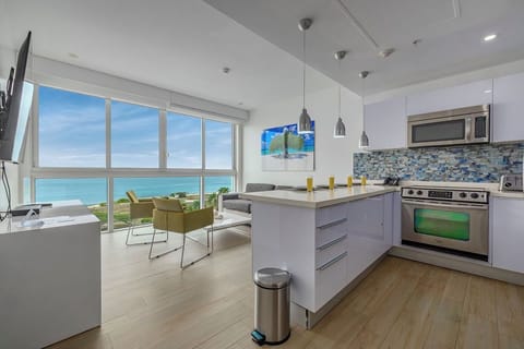 Your modern kitchen opens to a stunning ocean view, where you'll prepare meals with sparkling turquoise water as your backdrop. Sleek countertops and stainless appliances blend seamlessly with bright, airy living space.