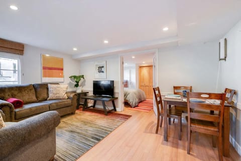 Open living and dining area with comfortable seating, a TV, and a cozy table for meals or relaxing together.
