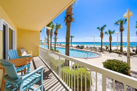 Your beachfront balcony offers stunning views of turquoise waters, swaying palms, and the sparkling pool below—perfect for morning coffee or sunset relaxation.