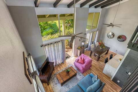 Comfortable living room space with large, open feel with beams and ceiling fans.