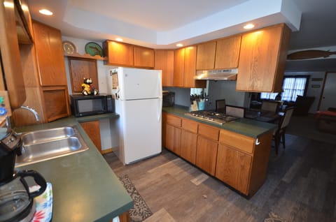 Kitchen - Cookware, Coffee maker, Microwave, Refrigerator, Slow cooker, Toaster, Toaster oven, Utensils, Stove top gas, Pantry items, Dining table.