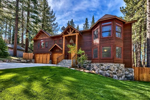 Beautiful mountain lodge nestled among towering pines with stone accents and natural wood siding in a peaceful forest setting.