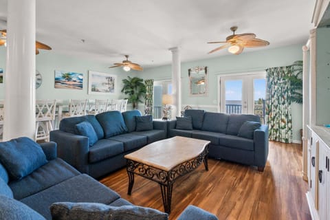 Blue sectional seating and ocean-view doors at Diamond Dunes B, an 8-bedroom rental from Thomas Beach Vacations
