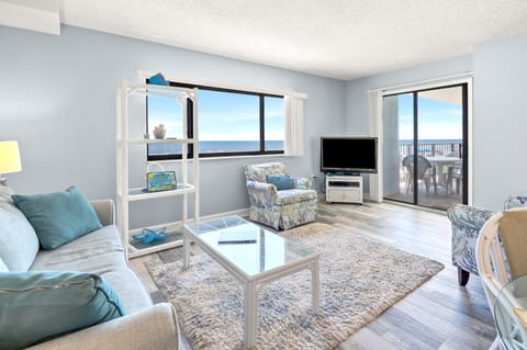 Living room with balcony doors and an ocean view at Shalimar 1B, a 2-bedroom condo from Thomas Beach Vacations