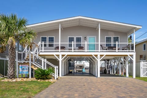 Two-story beach house with an elevated porch and blue door at Pelican's Perch, a 4-bedroom Cherry Grove rental