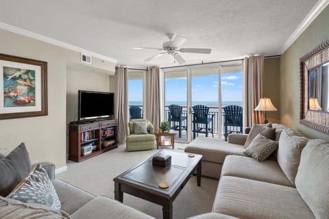 Sectional seating and sliding doors to the oceanfront balcony at South Shore Villas 1207, a 4-bedroom condo