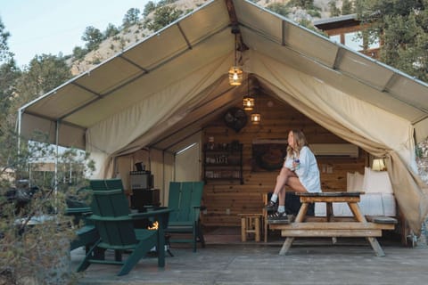 Spacious glamping tent with covered outdoor living space, cozy bed, dining area, and everything you need for a comfortable Southern Utah stay.