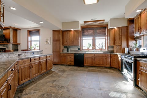 Large chef's kitchen with two ovens, gas range, dishwasher, fridge, wet bar, etc