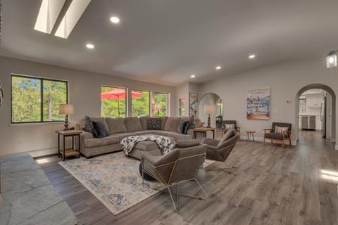 - Open living space with sectional and armchairs  
- Bright windows bring forest light indoors  
- Cozy Tahoe cabin for families and groups